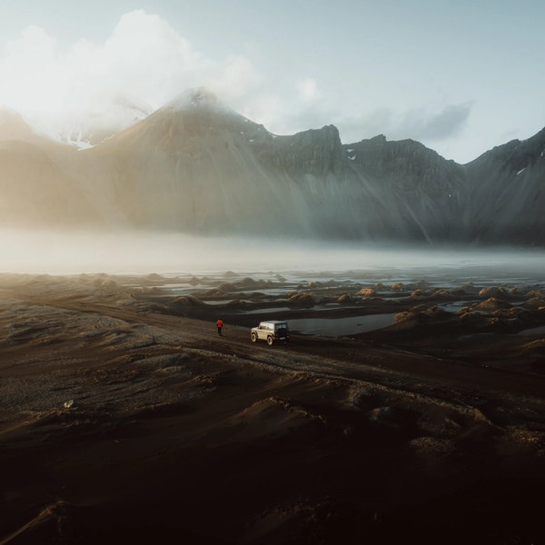 Drone shot of a car driving through a road in Iceland