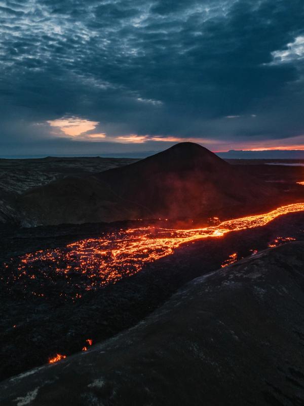 an aerial view of a volcano erupting at night .
