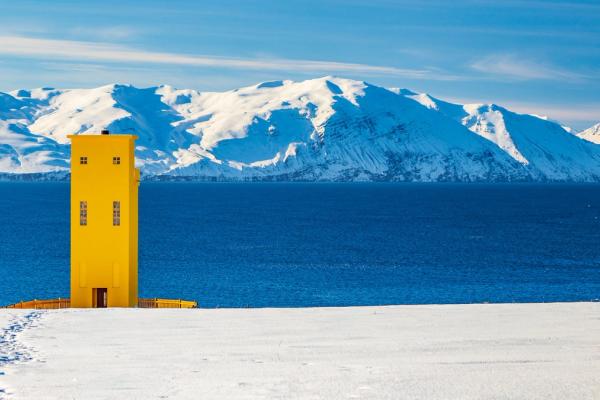 Husavik Lighthouse with snow-capped mountains in the background