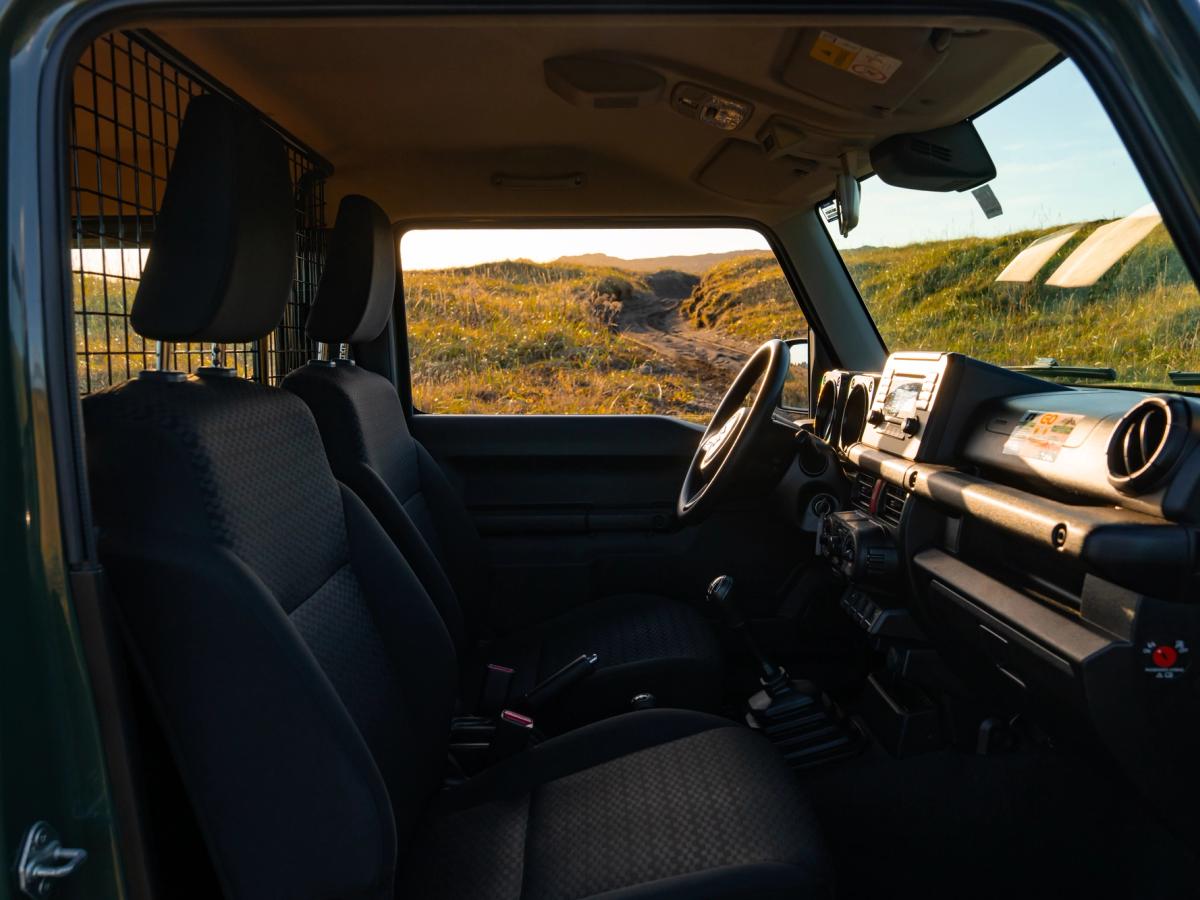 Blick in den Jimny-Innenraum Innenraum eines Suzuki Jimny mit Schaltgetriebe, durch die Beifahrertür fotografiert, mit Armaturenbrett und Sitzen