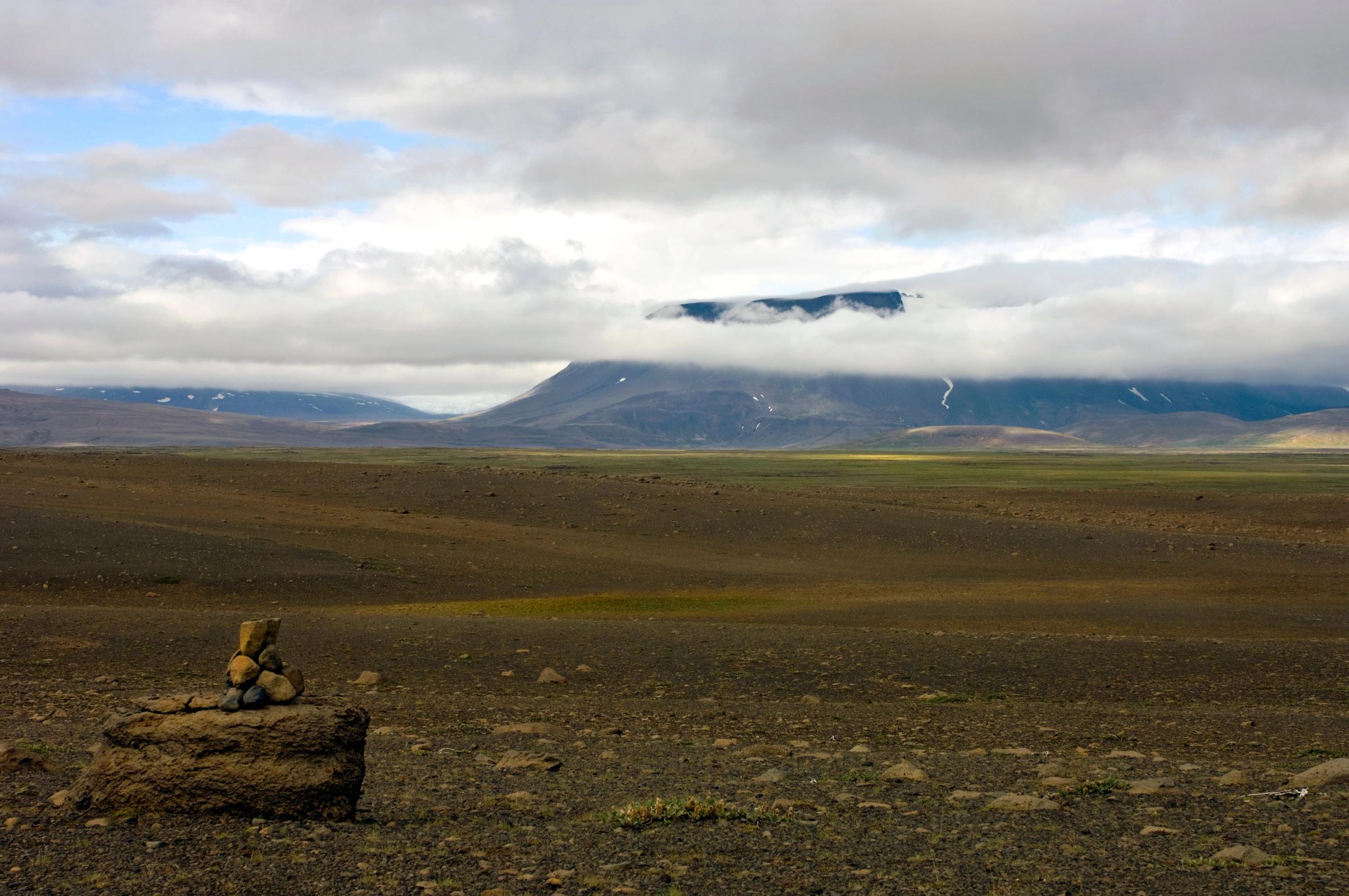 a pile of rocks sitting on top of a rock in the middle of a desert .