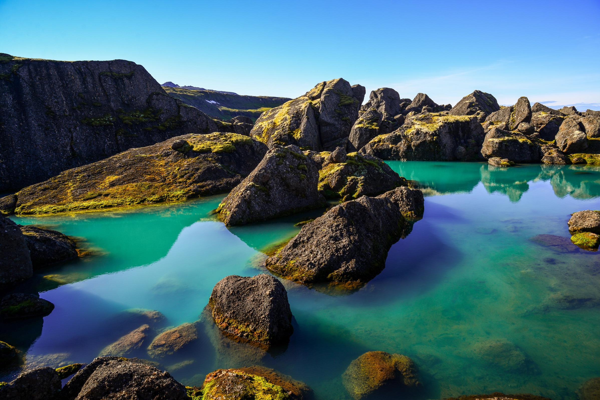 un gran cuerpo de agua rodeado de rocas y montañas.