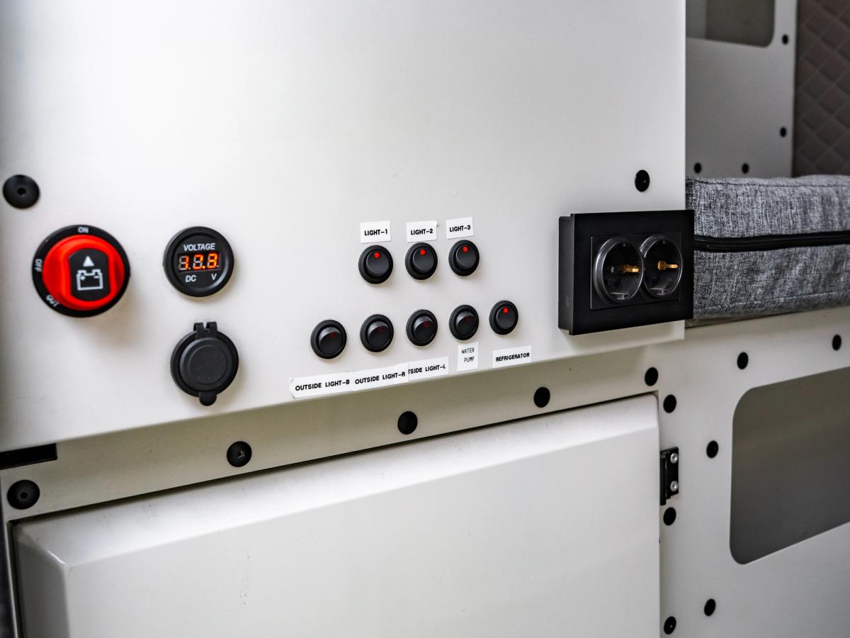 Panel de interruptores y enchufes Panel con interruptor de batería, indicador de voltaje, toma de 12 V y enchufes debajo de la nevera portátil