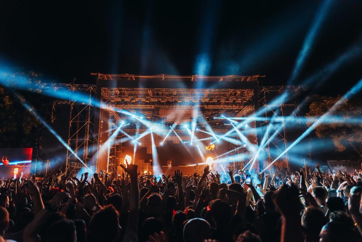 una multitud de personas está de pie frente a un escenario en un concierto de un festival de música en Islandia.