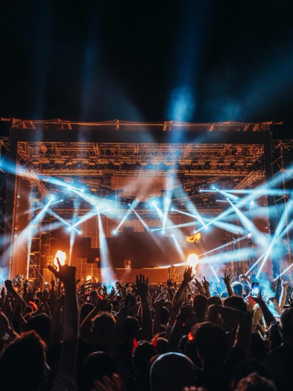 a crowd of people are standing in front of a stage at a concert at a music festival in iceland.