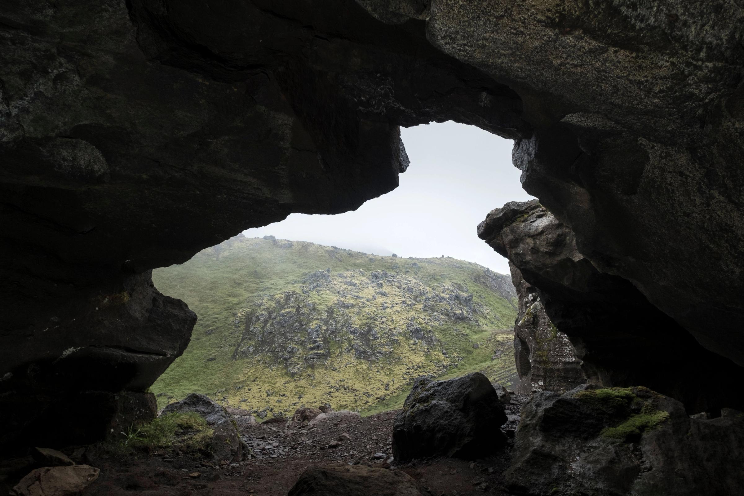 vista de una montaña con niebla desde el interior de una cueva
