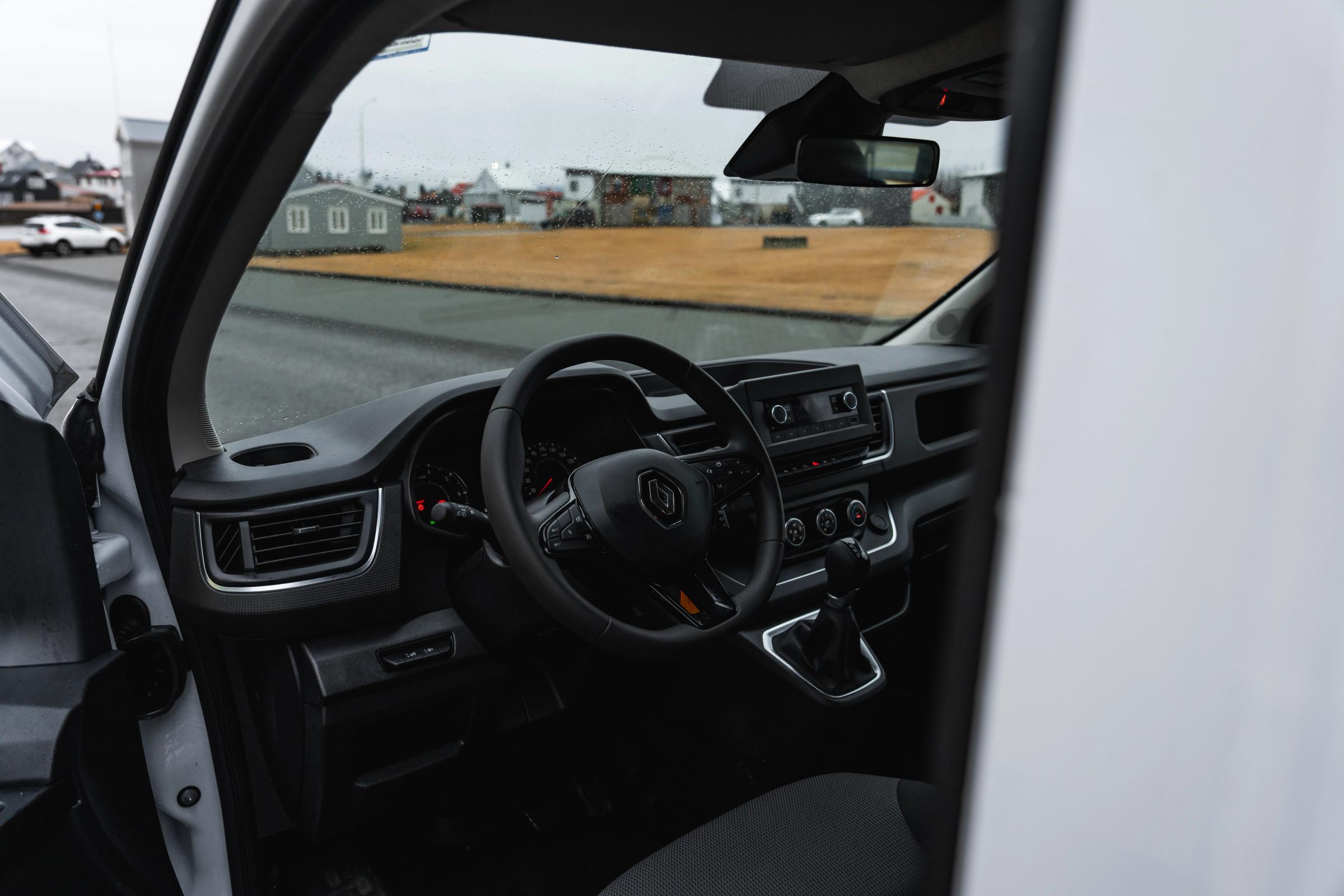 Vista interior de una miniván Renault Trafic, con el volante y el salpicadero vistos a través de la puerta abierta