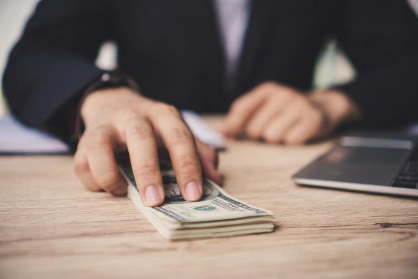 Hombre devolviendo un taco de dólares