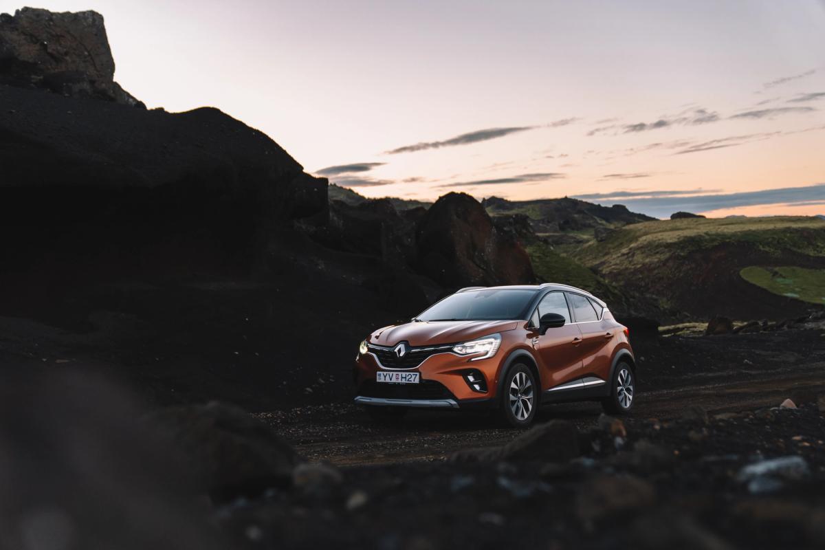 Renault Captur wide view parked on gravel among dark lava rocks at dusk