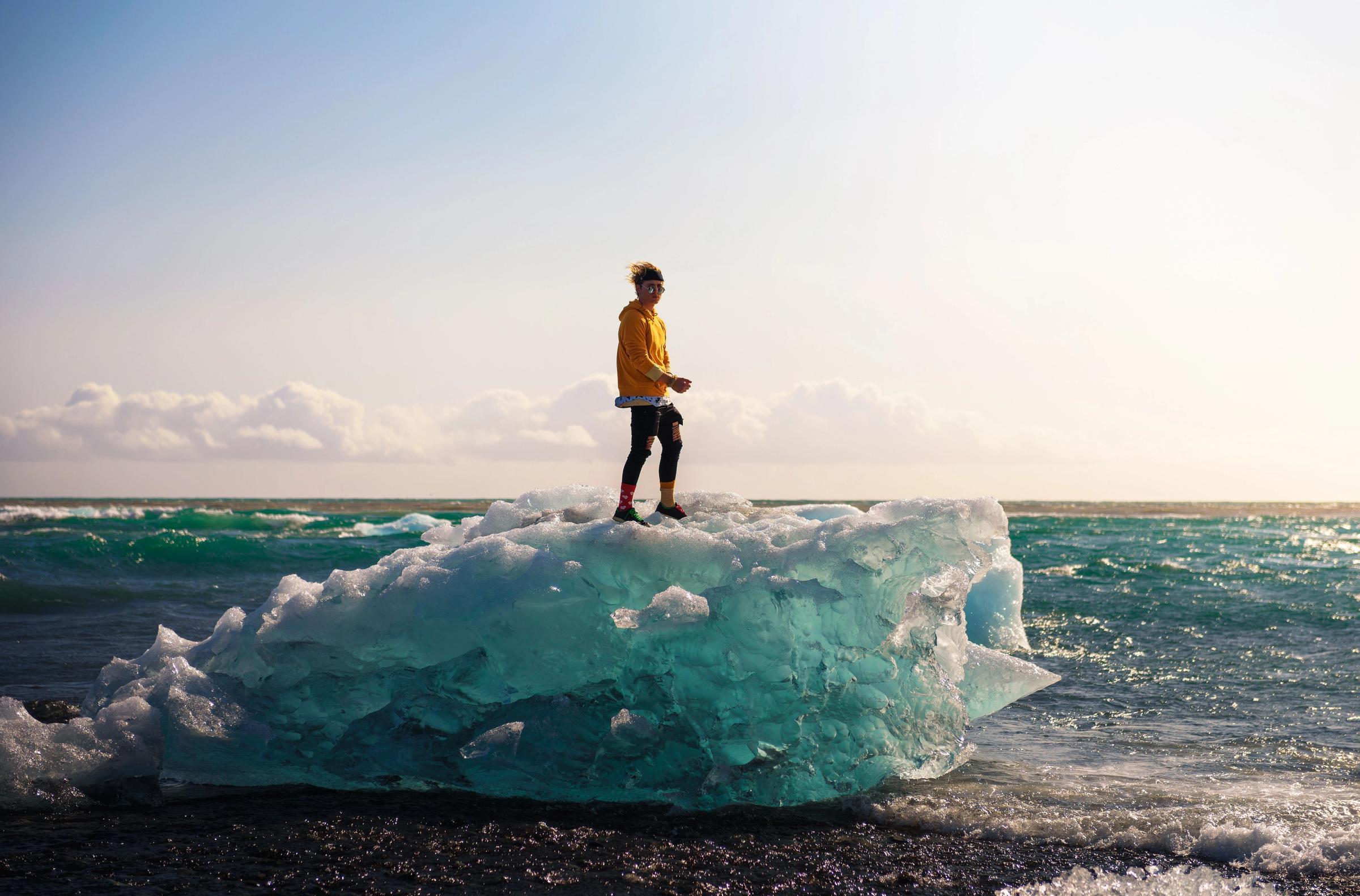 Turista sobre la cima de un iceberg en Diamond Beach