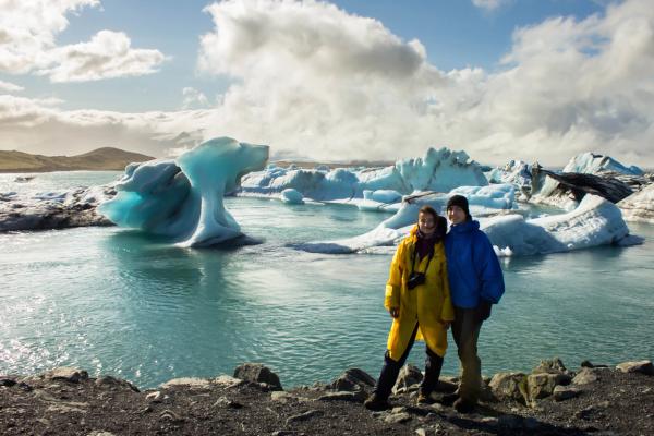 un hombre y una mujer delante de una laguna glaciar
