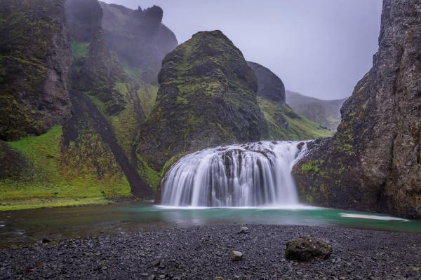 Wide waterfall falling into a pond