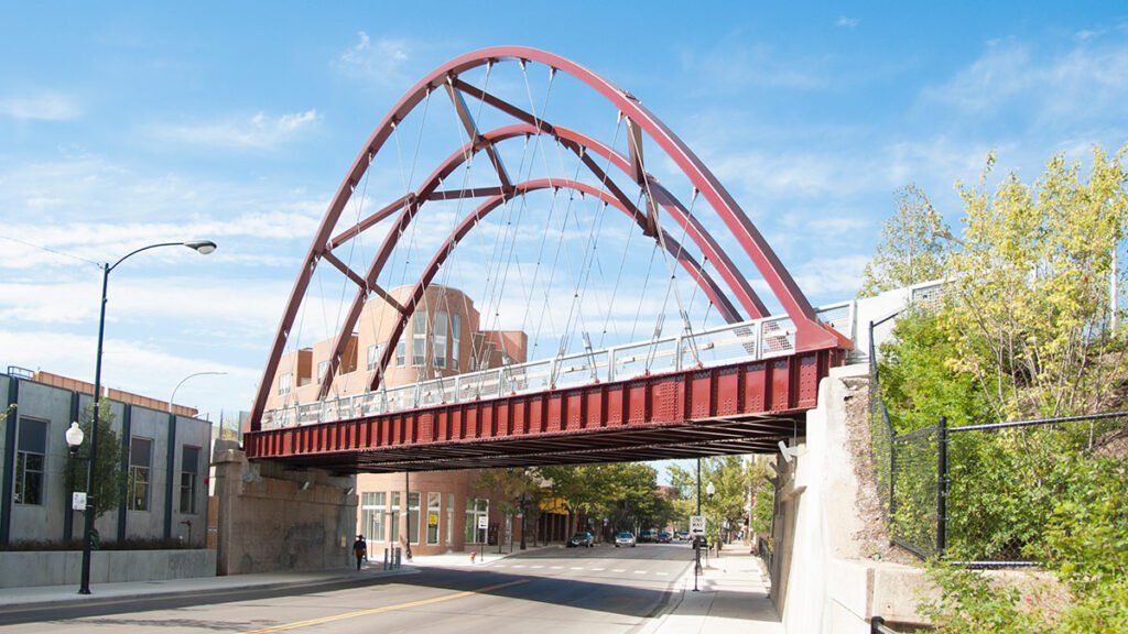 The 606 Bloomingdale Trail red steel arch bridge over a Chicago street