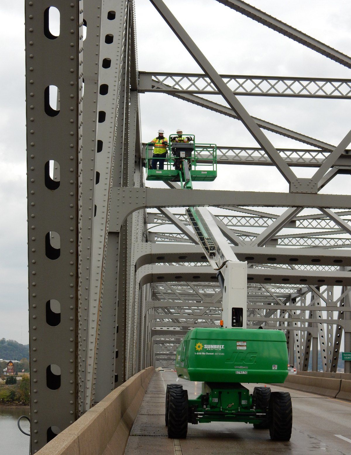 HBM inspectors in an aerial lift inspecting steel truss members of a major bridge