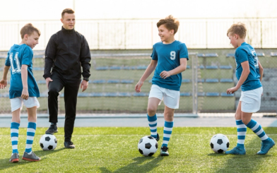 Fotballtrener på trening med barn