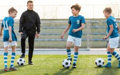 Fotballtrener på trening med barn