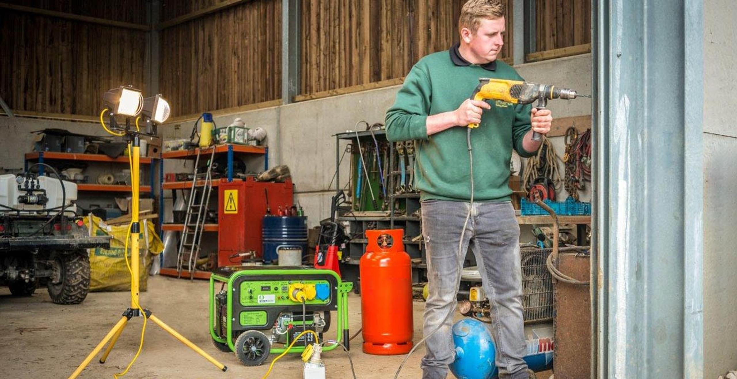 Green Gear LPG generator in a workshop, with the gas cylinder and a work light