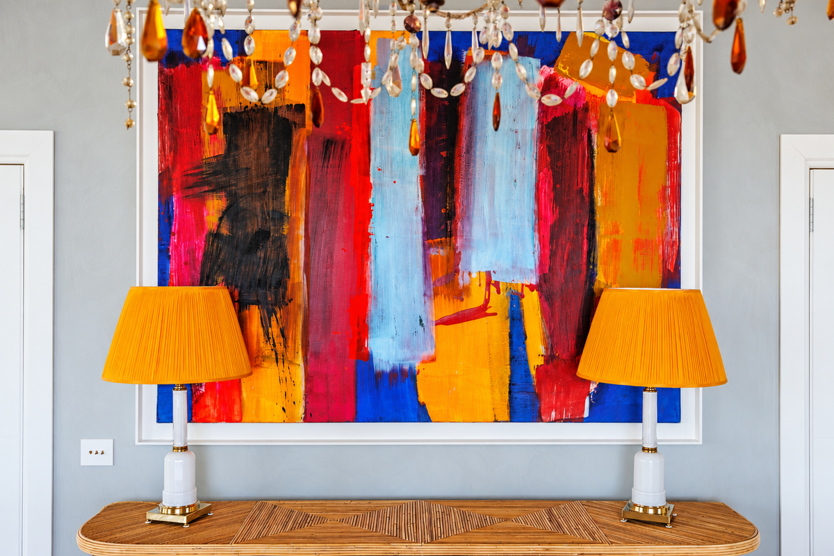 Abstract painting in red, blue and orange between two orange lamps