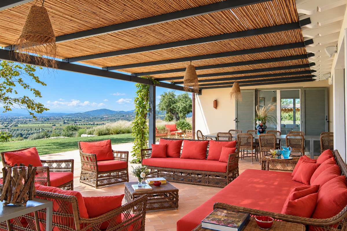 Veranda with wicker sofas and red cushions, the hills beyond