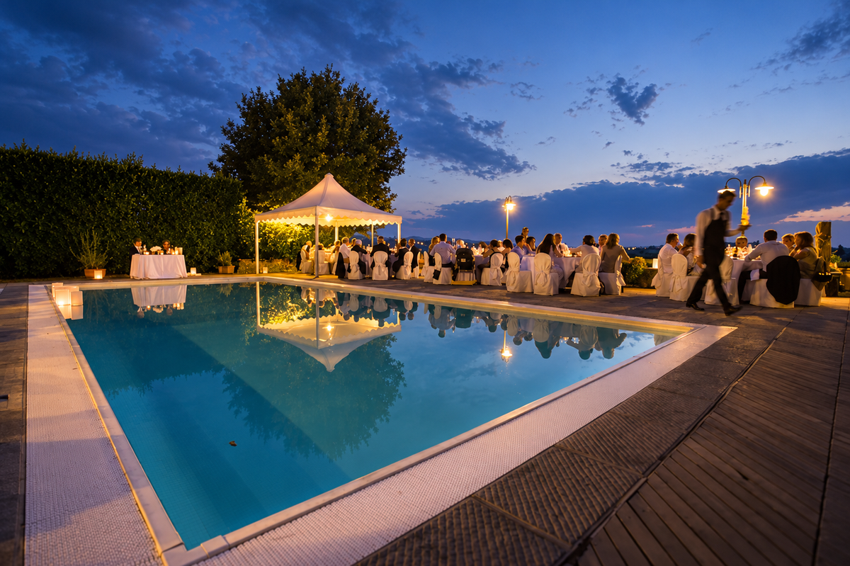 Reception by the pool at dusk with a gazebo and the lights of Florence