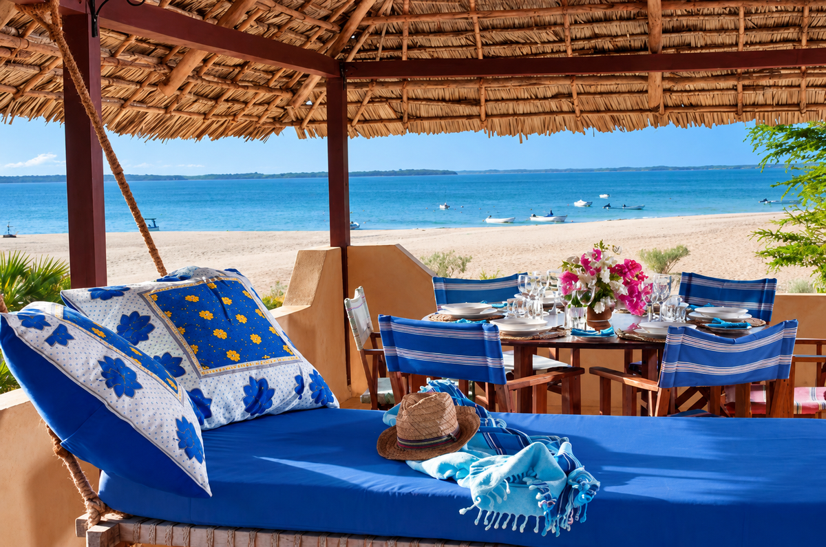 Beachfront veranda with a blue daybed and dining table facing the sea