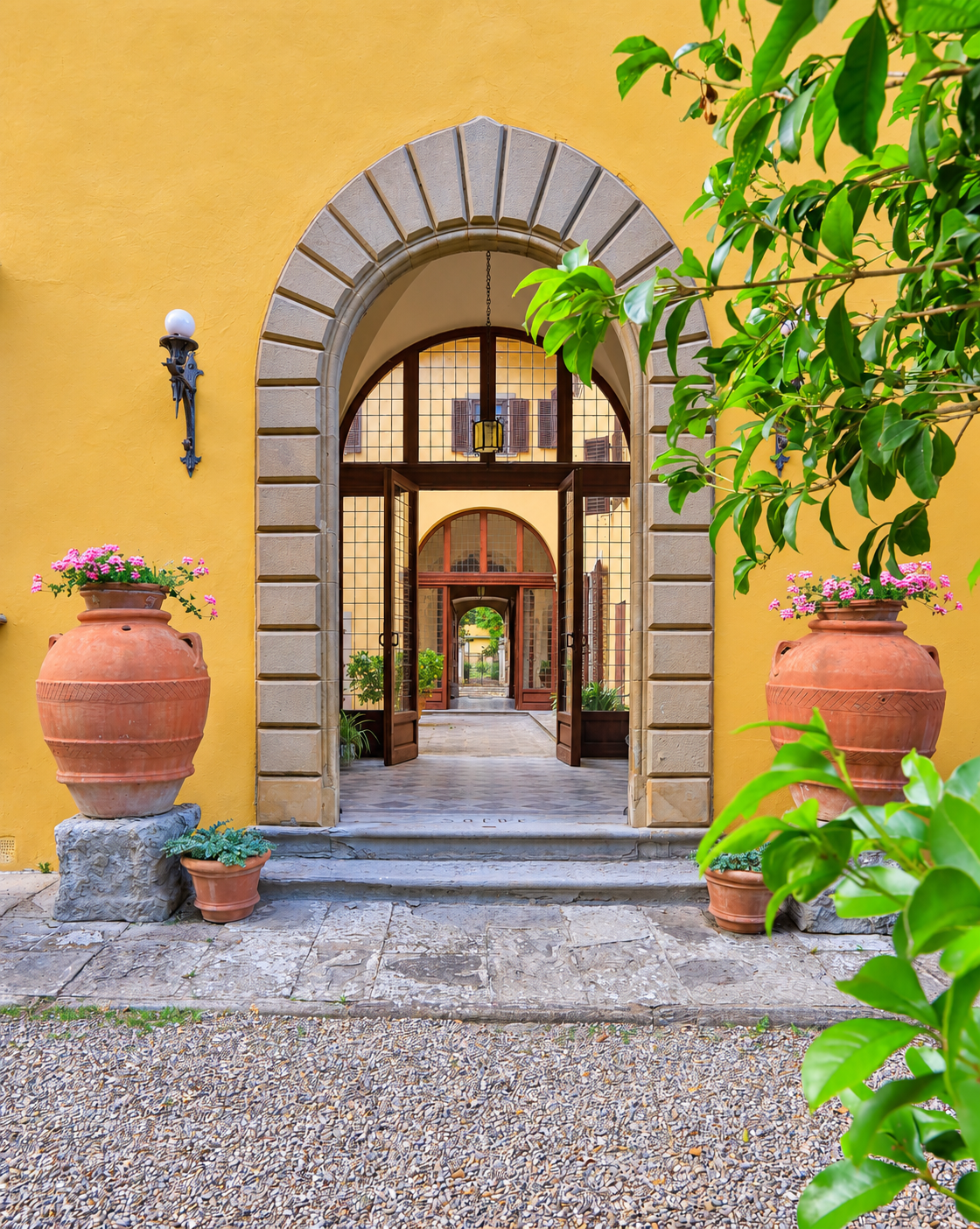 Stone arch with terracotta urns, looking through the house to the garden