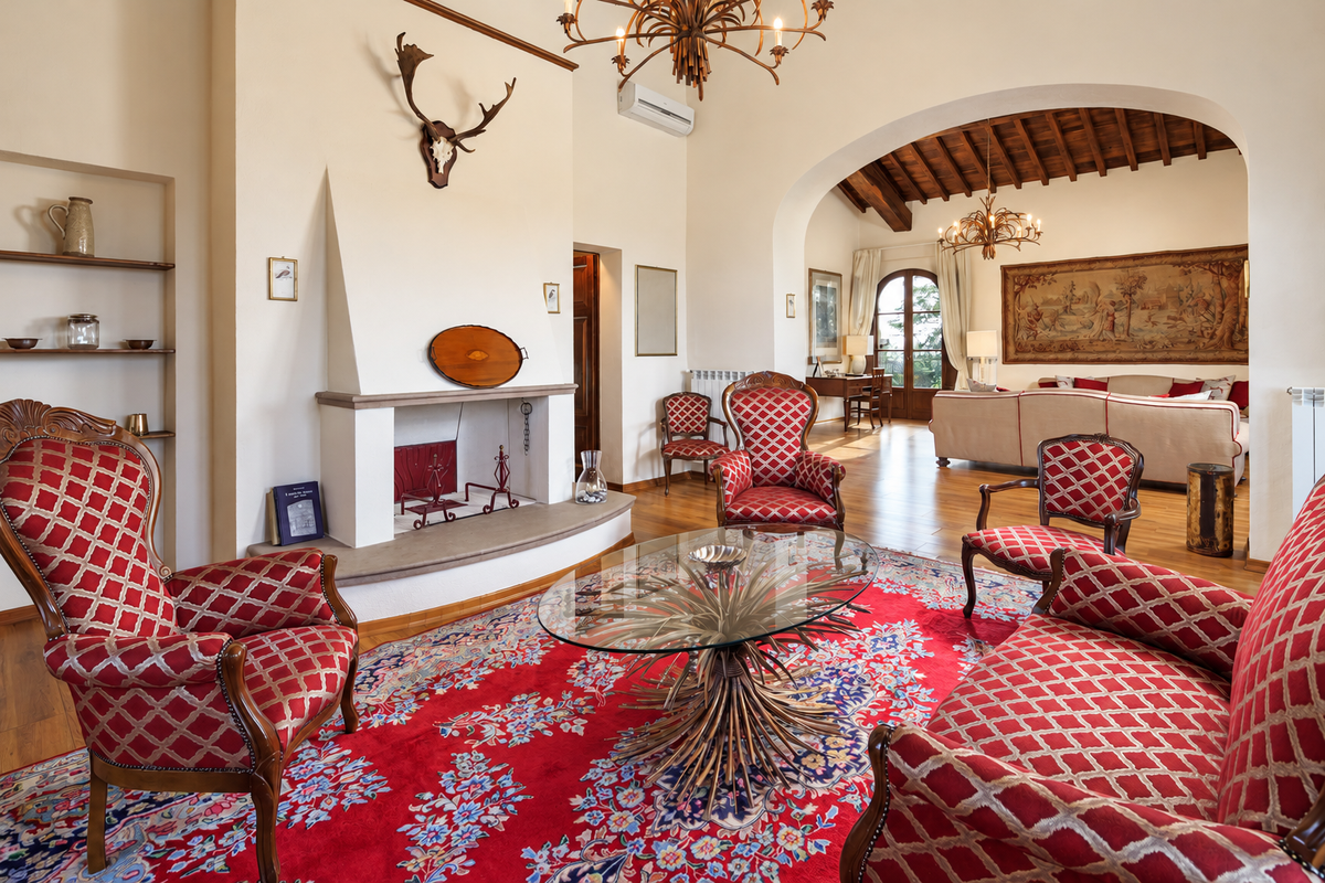 Red drawing room with a fireplace and antique armchairs
