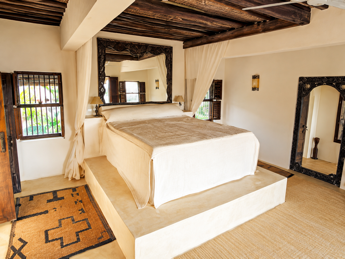 King bedroom on a plinth under timber beams
