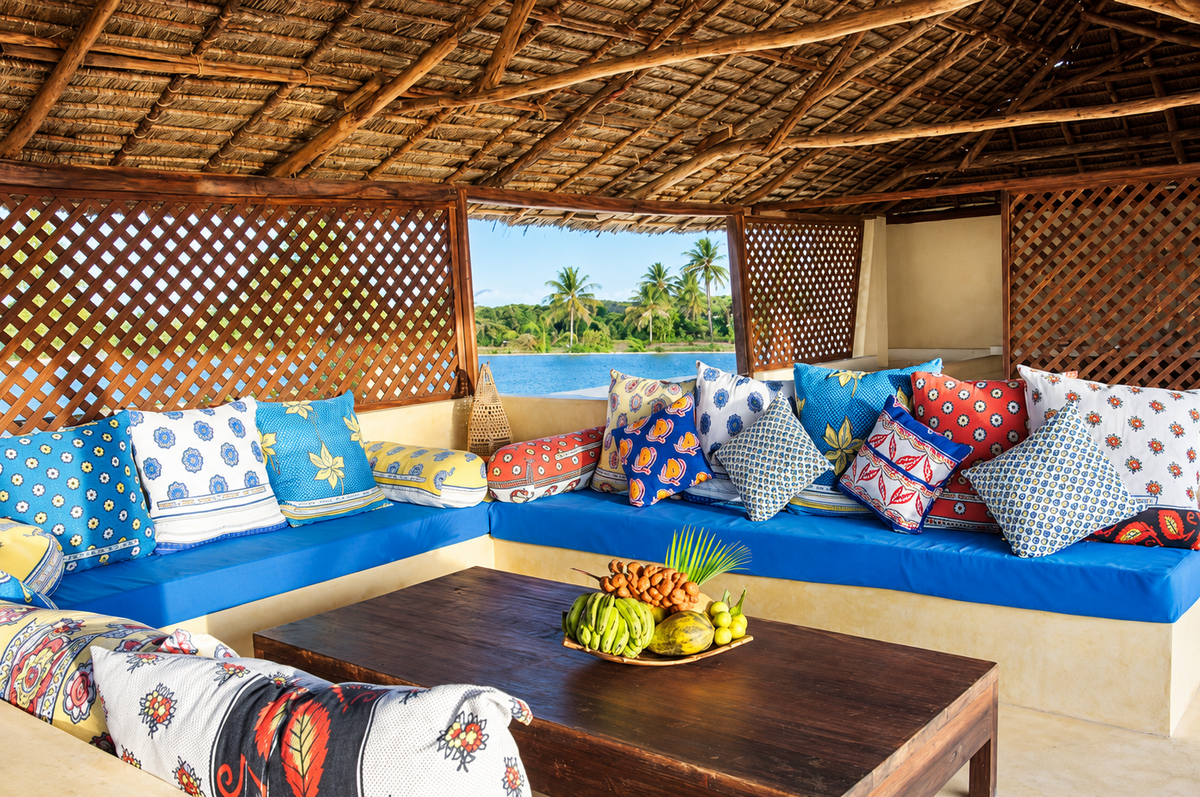 Lounge with colourful Swahili cushions under a thatched roof