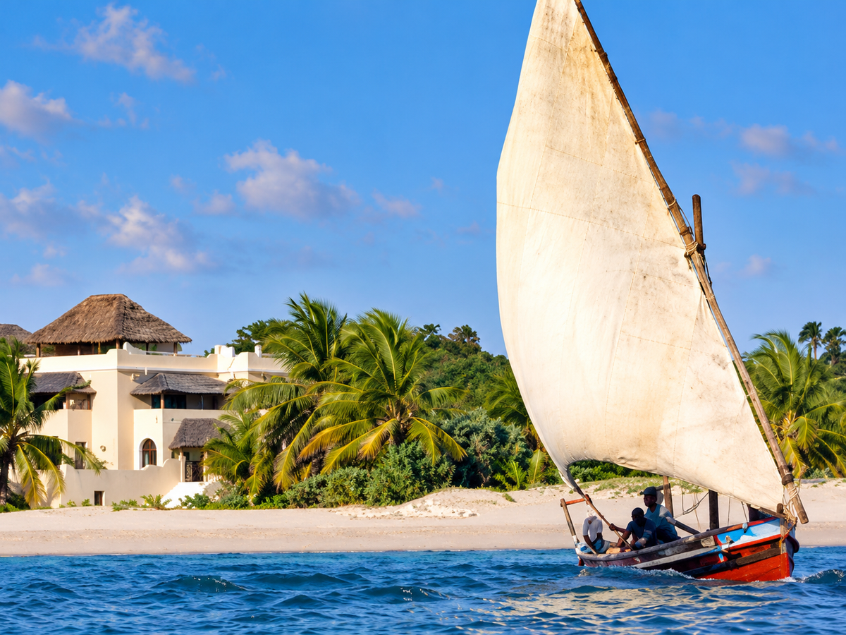 Dhow sailing past the beach and villas