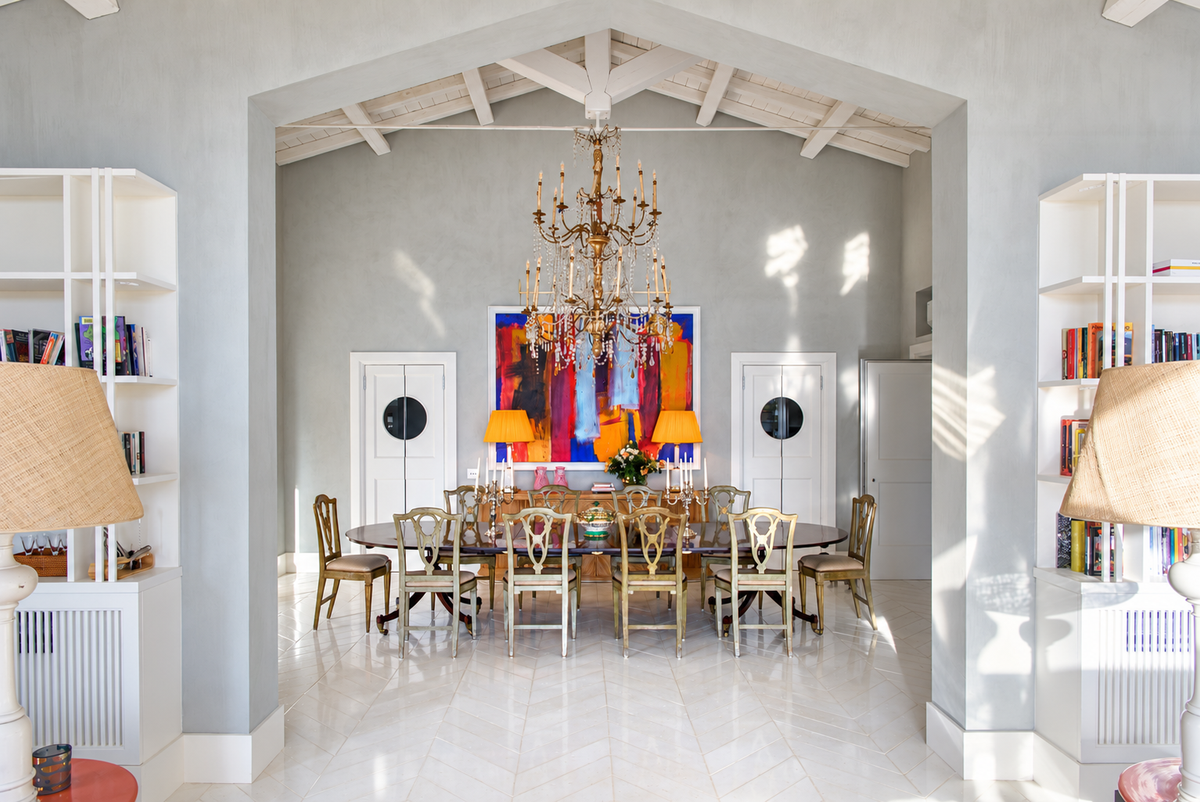 Dining room with an antique chandelier and a long table under a vaulted ceiling