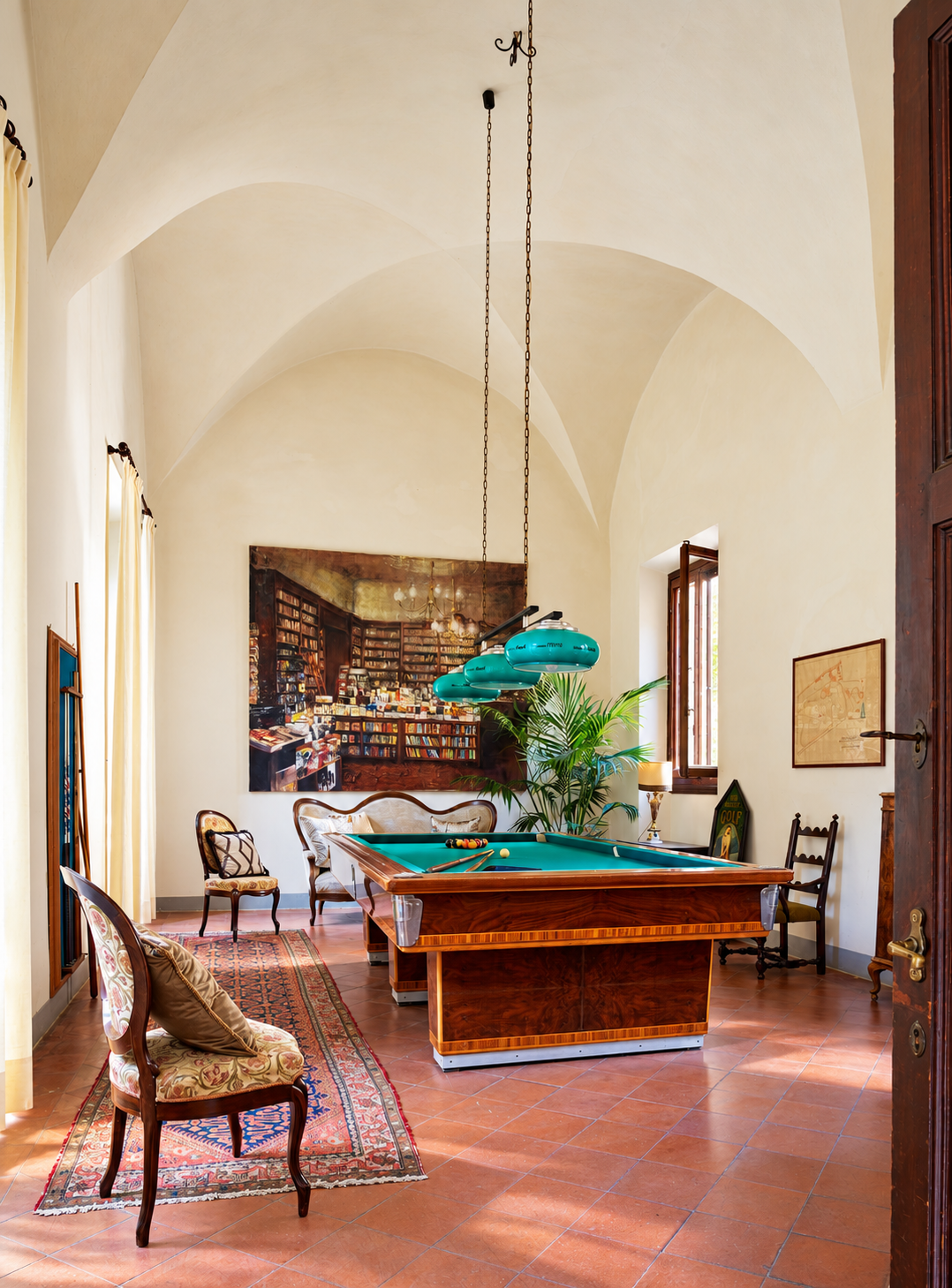 Vaulted billiard room with a painting of a library