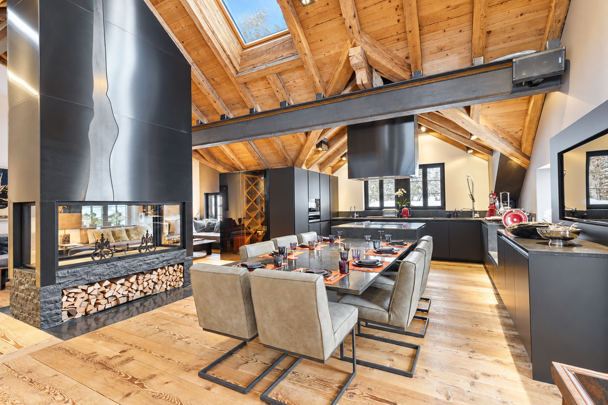 Dining table for twelve beside the fireplace, under timber beams and a skylight