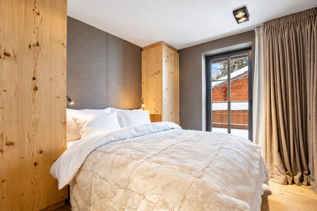 Bedroom with a door onto a snowy balcony