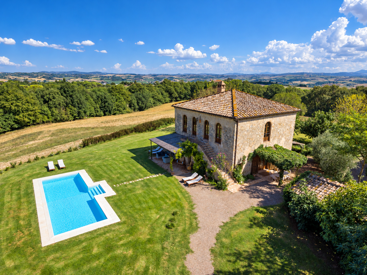 Aerial view of the villa and pool among fields and woods