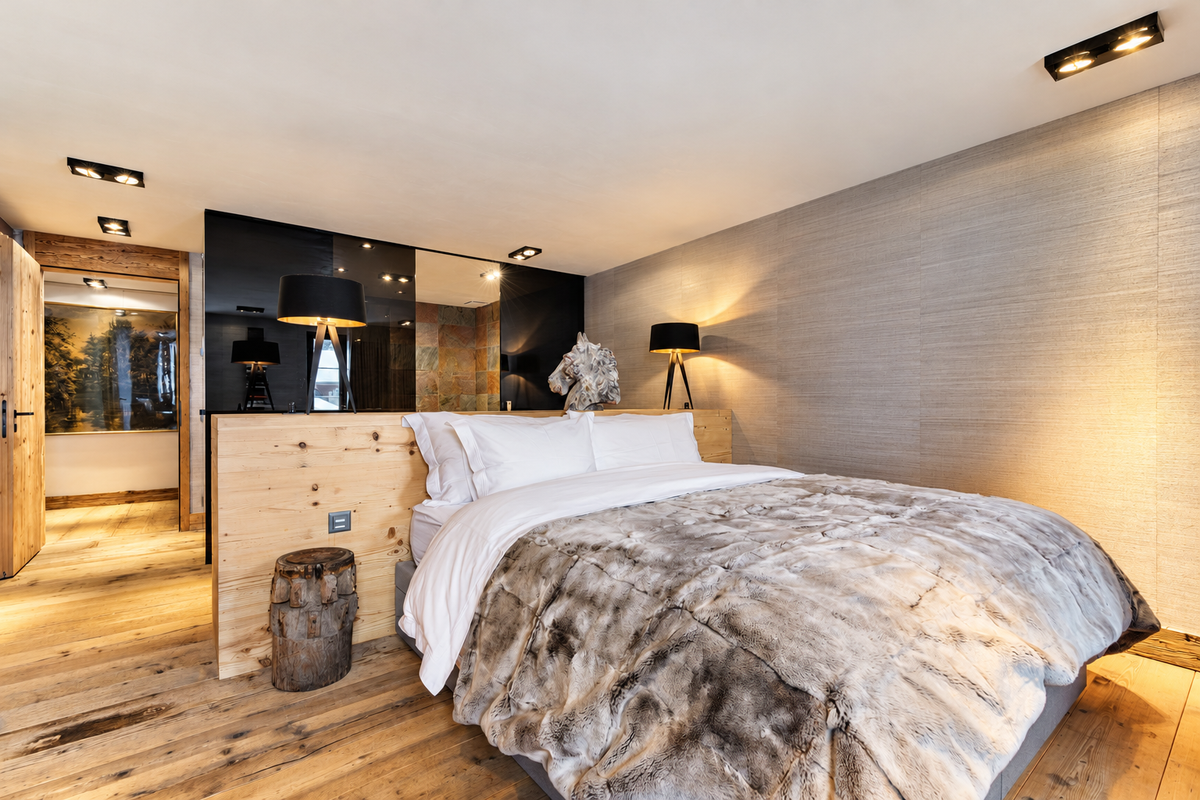 Bedroom with a timber headboard wall and a fur throw