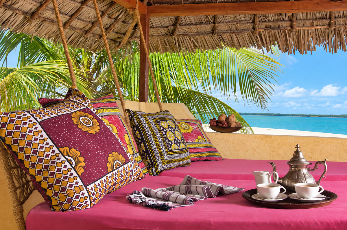 Pink daybed with Swahili cushions and mint tea facing the sea