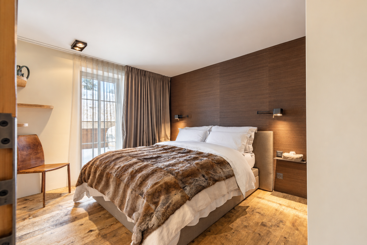 Bedroom with a fur throw beside a tall window