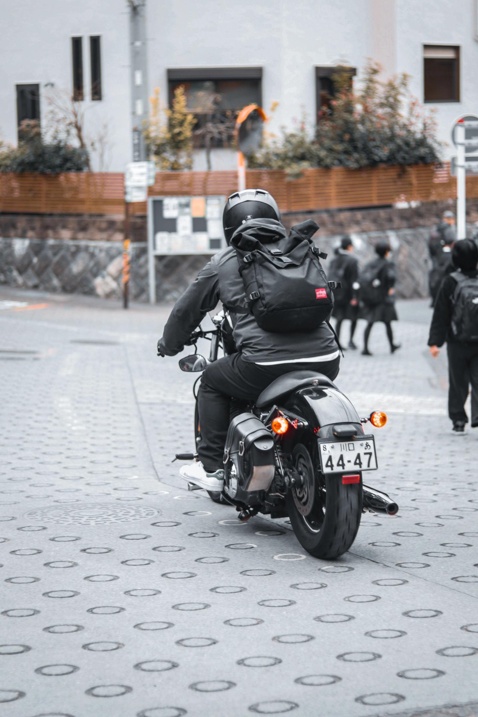 Motard de dos sur une moto dans une rue de Tokyo