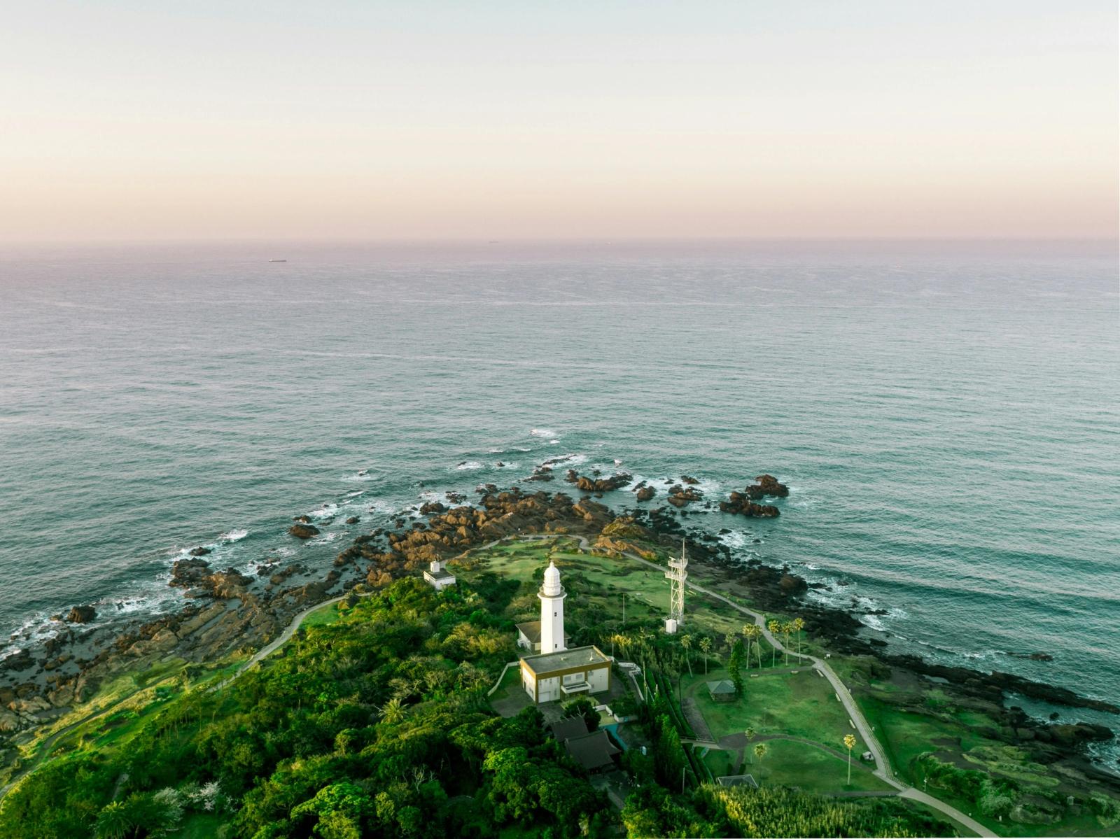 Phare blanc sur un cap verdoyant au-dessus de l'océan