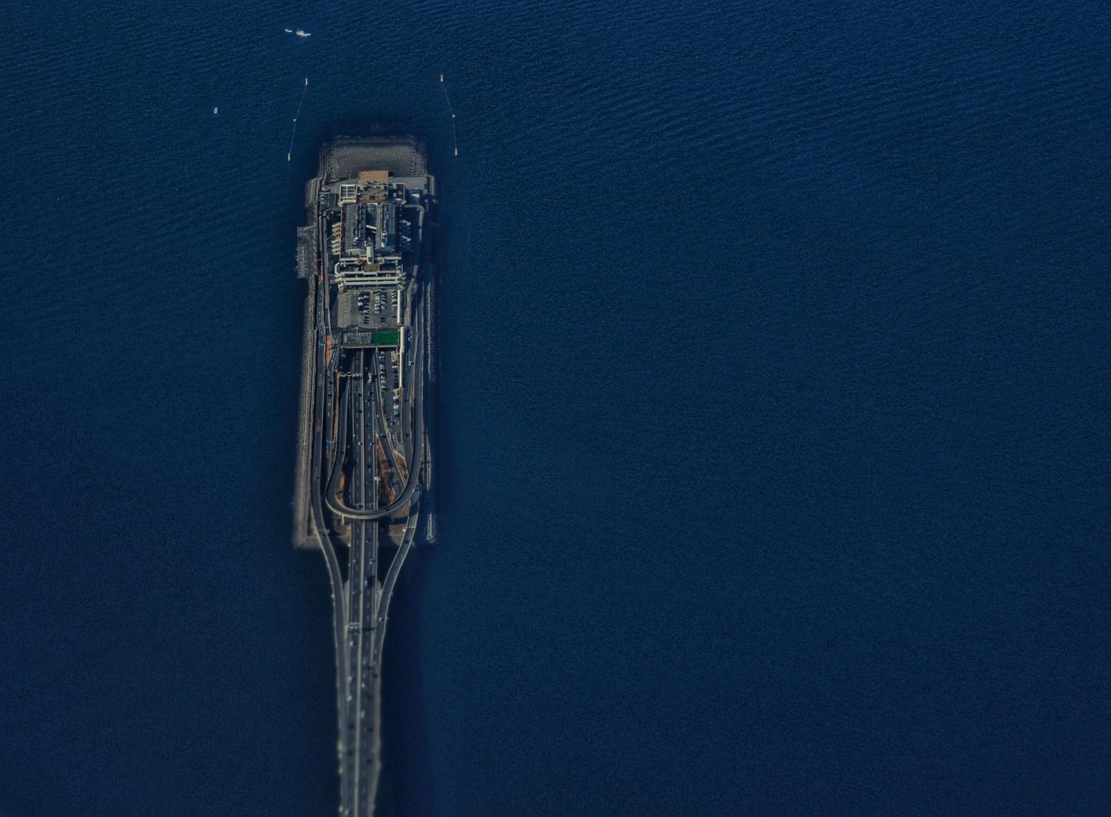 Jetée s'avançant dans la mer bleue, vue du ciel