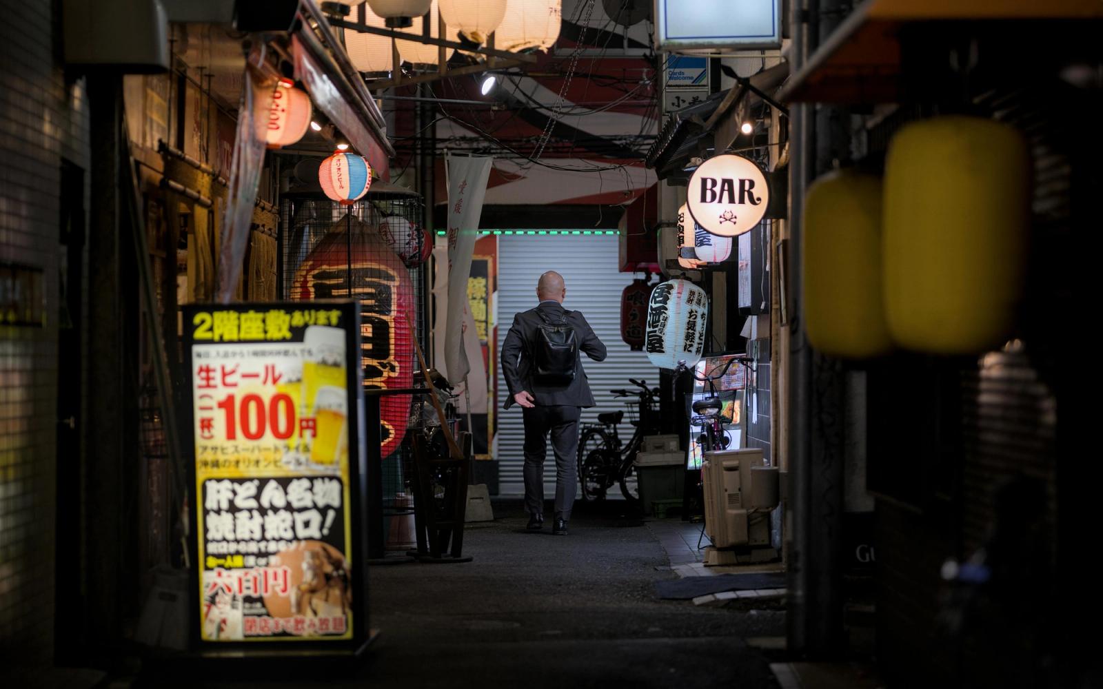 Ruelle animée de petits bars et restaurants le soir à Tokyo