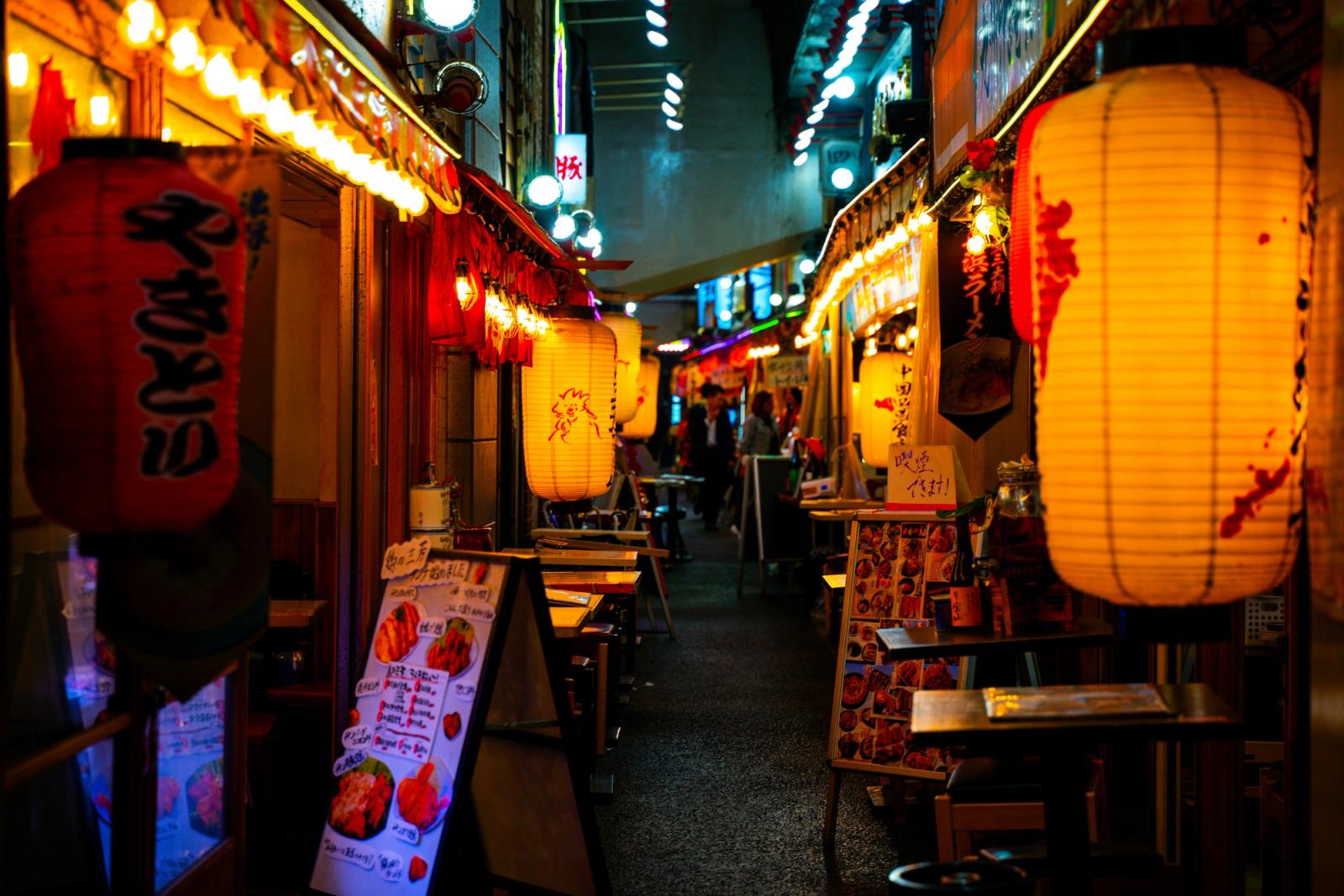Ruelle d'izakayas éclairée par des lanternes la nuit à Tokyo