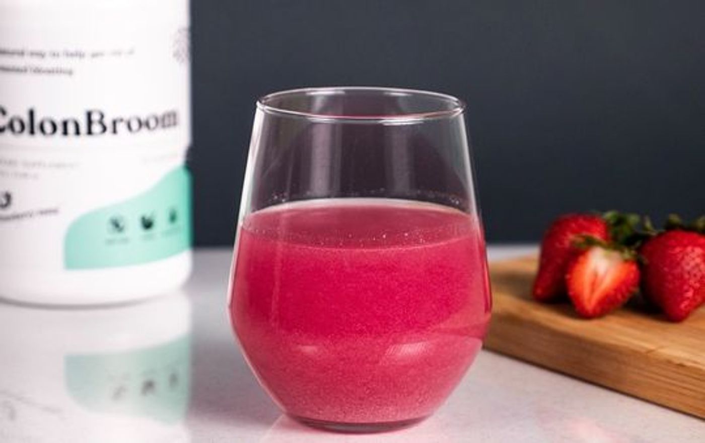 colonbroom container behind a glass of colon broom
