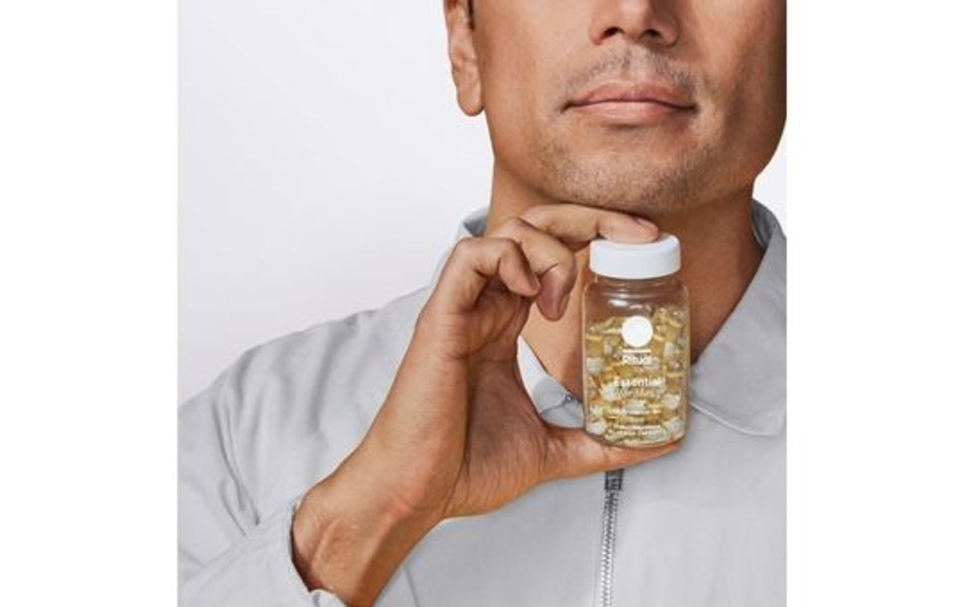 man holding a bottle of ritual essentials vitamins for men