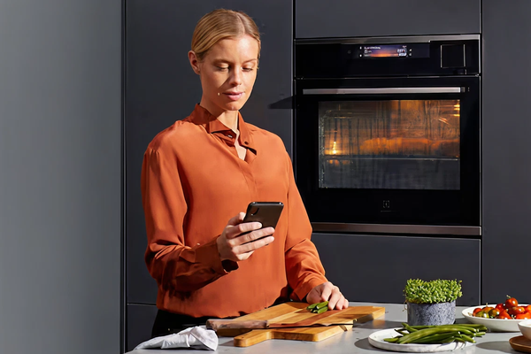 Women looks at her phone while cooking food