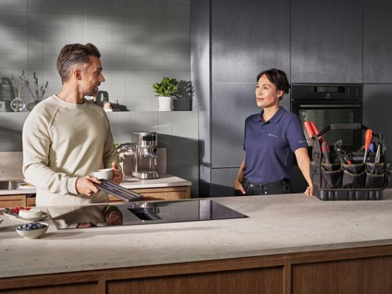 Technician and customer in kitchen