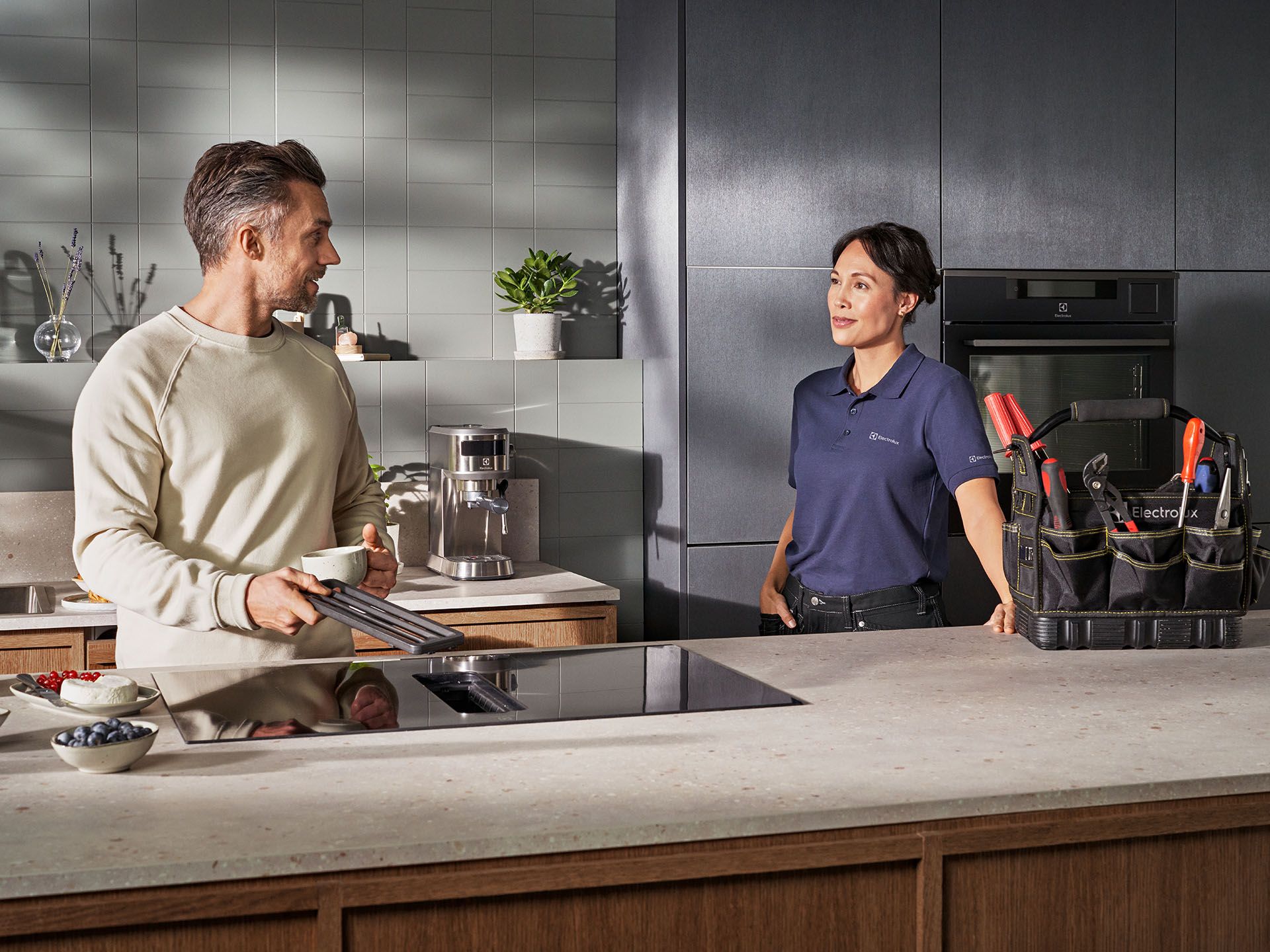 Technician and customer in kitchen