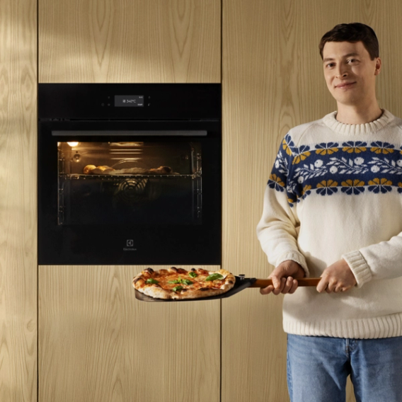 man cooking a pizza in in oven