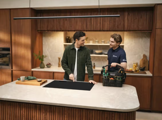 Electrolux servicetekniker reparerer kogeplade hos kunde i hjemmet